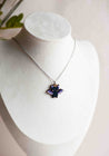 Bat-shaped pendant on a necklace displayed on a mannequin bust.