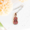 Necklace with a violin-shaped pendant on a light background