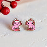 Pink axolotl earrings with Santa hats on a white background with red berries.