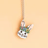 Necklace with a bunny pendant featuring flowers on a beige background