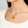 Necklace with a sunflower pendant worn by a person