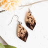 Wooden howling wolf drop earrings with mountain and crescent moon details.