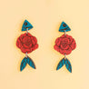 A pair of hand-painted wooden earrings with a floral design in red and blue colors, displayed against a yellow background.turquoise red rose dangle earrings hand-painted wooden earrings